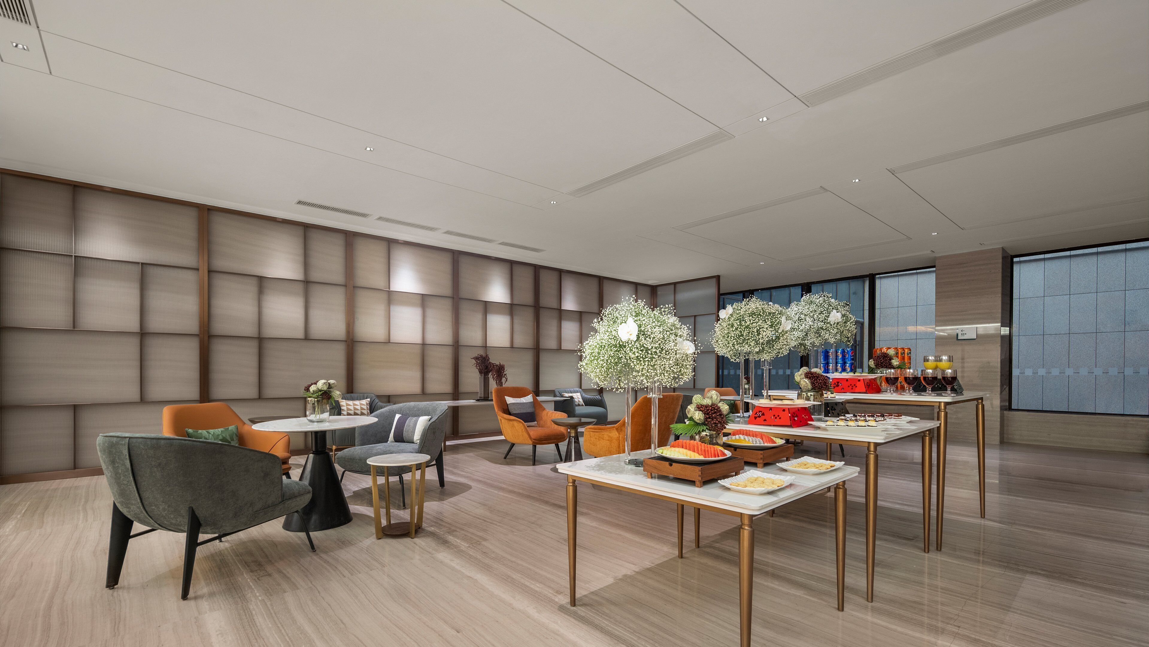 A modern dining area with a high ceiling, recessed lighting, and a large window providing natural light.
