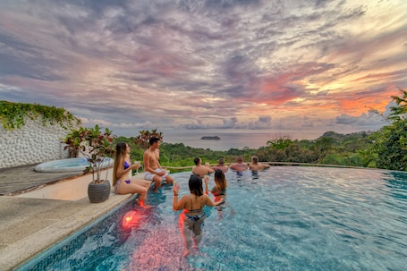 Una piscina al aire libre, sombrillas, sillones reclinables de piscina