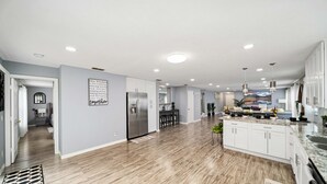 A spacious kitchen with white cabinets, a granite countertop, and a large island.
