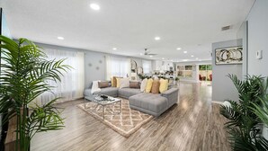 A spacious living room with a grey sectional sofa, a coffee table, and a rug.