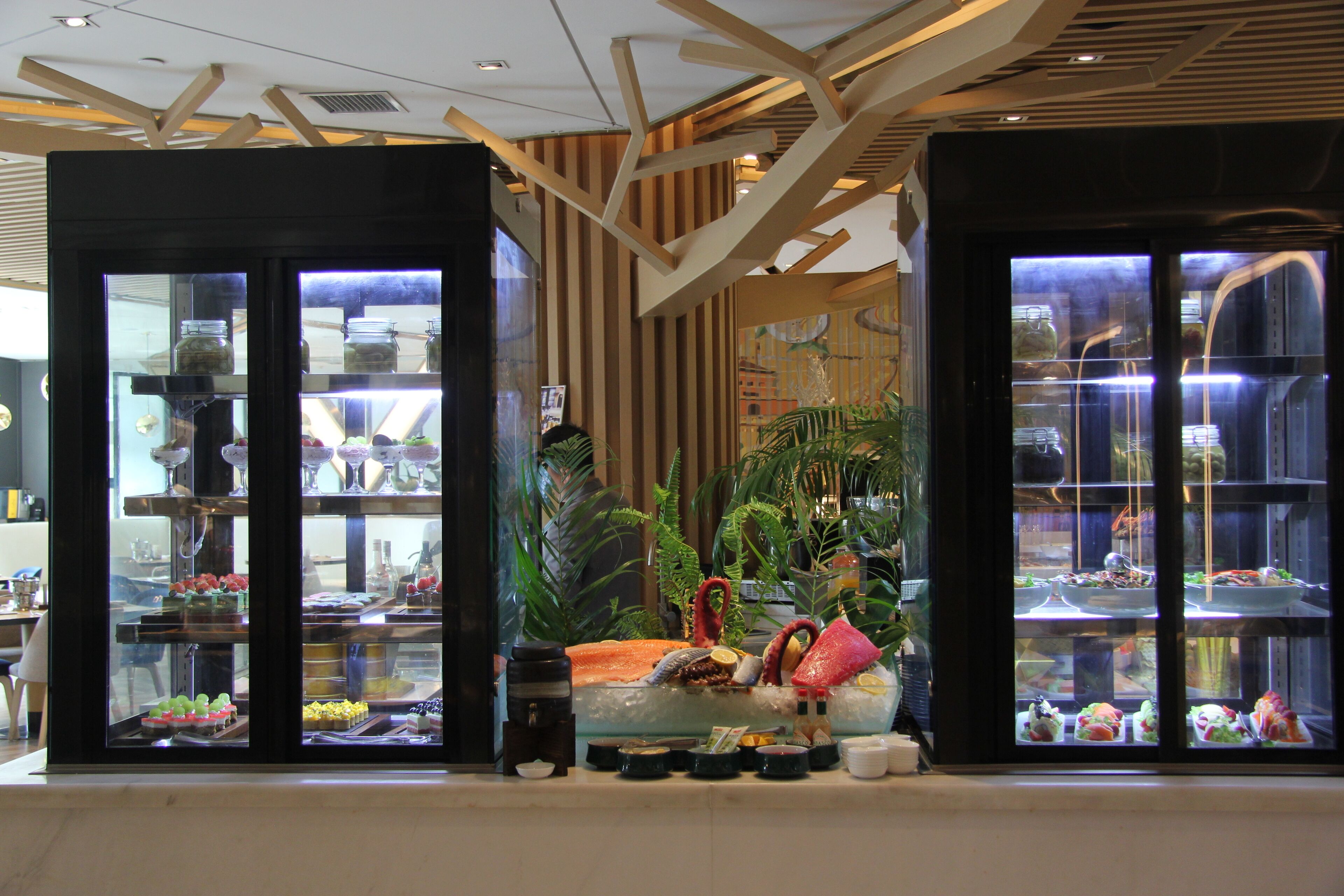 A modern interior with glass display cases containing various food items.