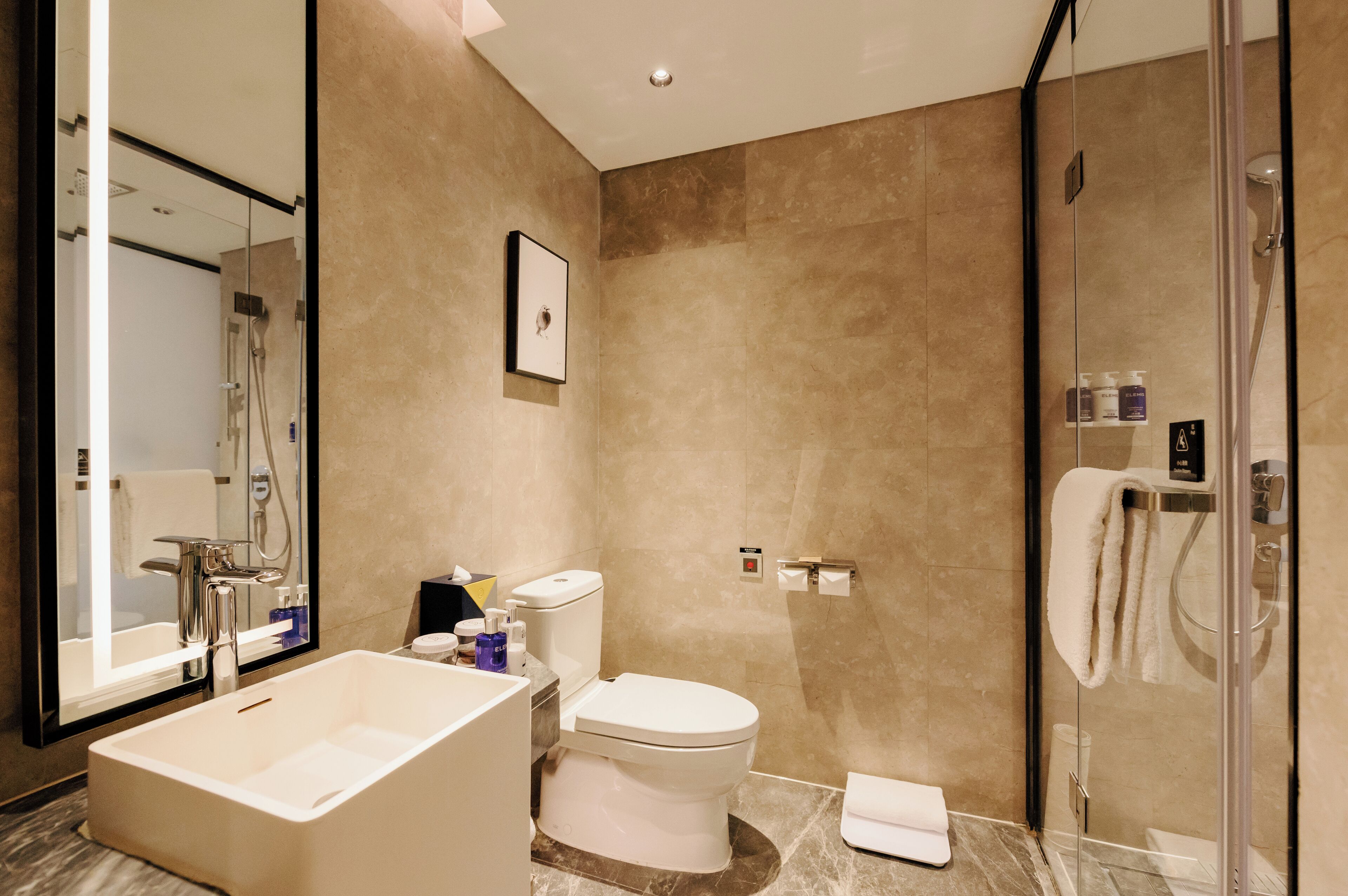 A modern bathroom with a bathtub, toilet, and glass-enclosed shower.