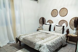 Cozy retreat with a large bed, wooden headboard, and woven decorative elements.