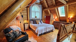 Um quarto de cabana de tronco aconchegante, com uma cama, uma poltrona, uma mesa de cabeceira e um aparador.