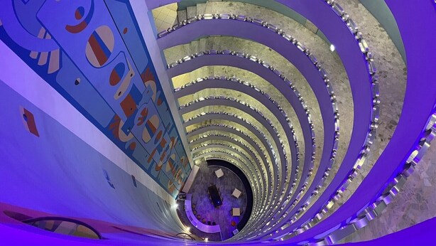 Un escalier en colimaçon au design moderne, caractérisé par une série de cercles concentriques et des rampes métalliques.