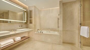 Un baño moderno con dos lavamanos, una bañera y una cabina de ducha de vidrio.