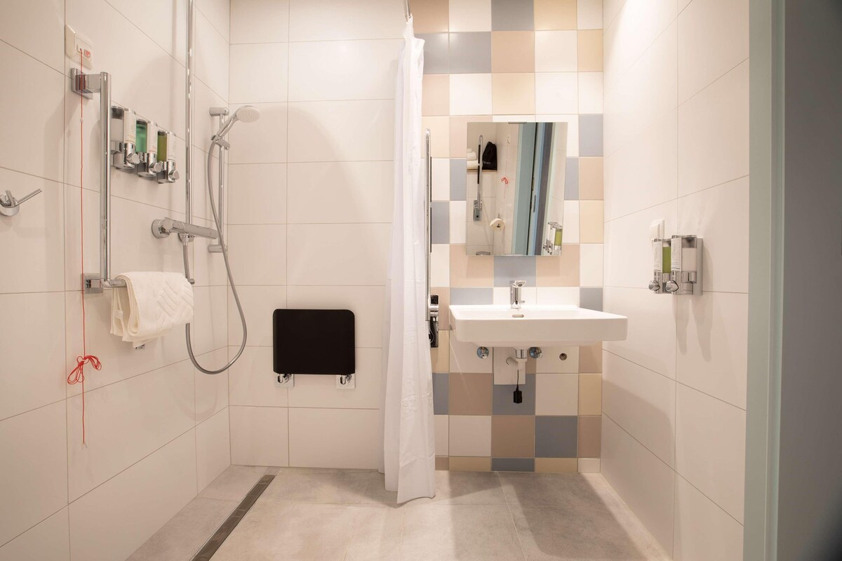 Une salle de bain moderne équipée d’une douche, de toilettes et d’un lavabo.