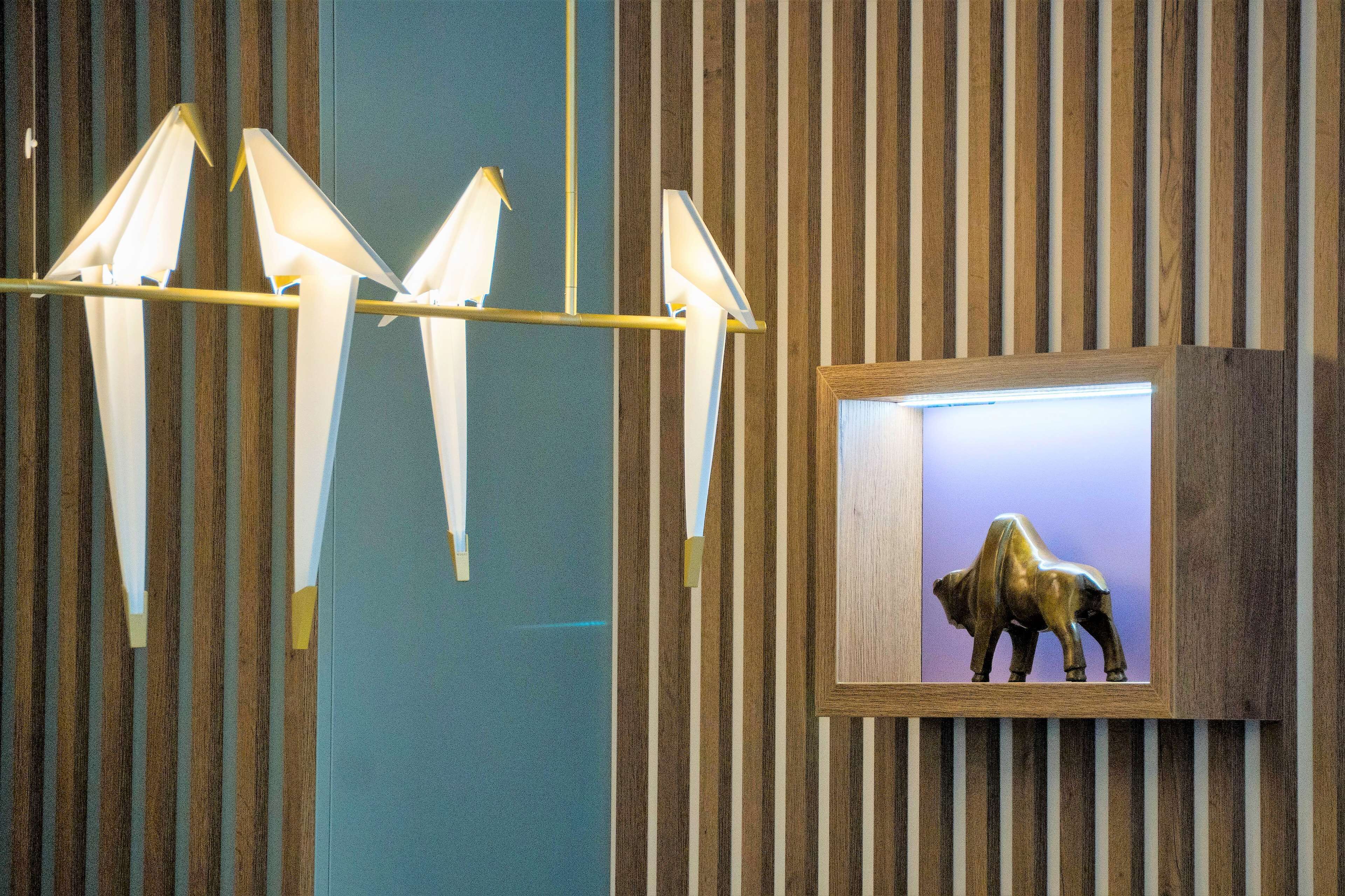 Una pared con listones verticales de madera y un cuadro enmarcado de un búfalo.