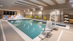 An indoor swimming pool with lounge chairs and a changing station.