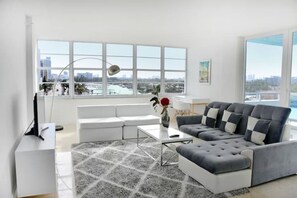 Relax in this serene urban retreat with a panoramic city view, comfortable seating, and a stylish coffee table.