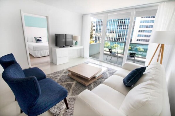 Relax in a spacious living room with a city view, flat-screen TV, and comfortable seating.