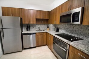 Fully equipped kitchen with refrigerator, dishwasher, microwave, and oven.