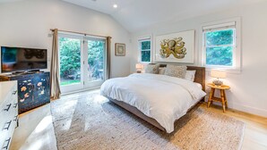 A bedroom with a large bed, a television on a cabinet, and a ceiling fan. - Oasis heaven close to everything you need! (East Hampton)