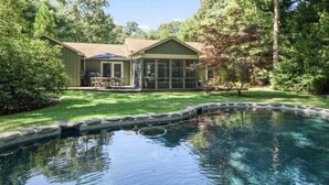 A house with a swimming pool, a covered patio, and a well-maintained lawn. - Oasis heaven close to everything you need! (East Hampton)