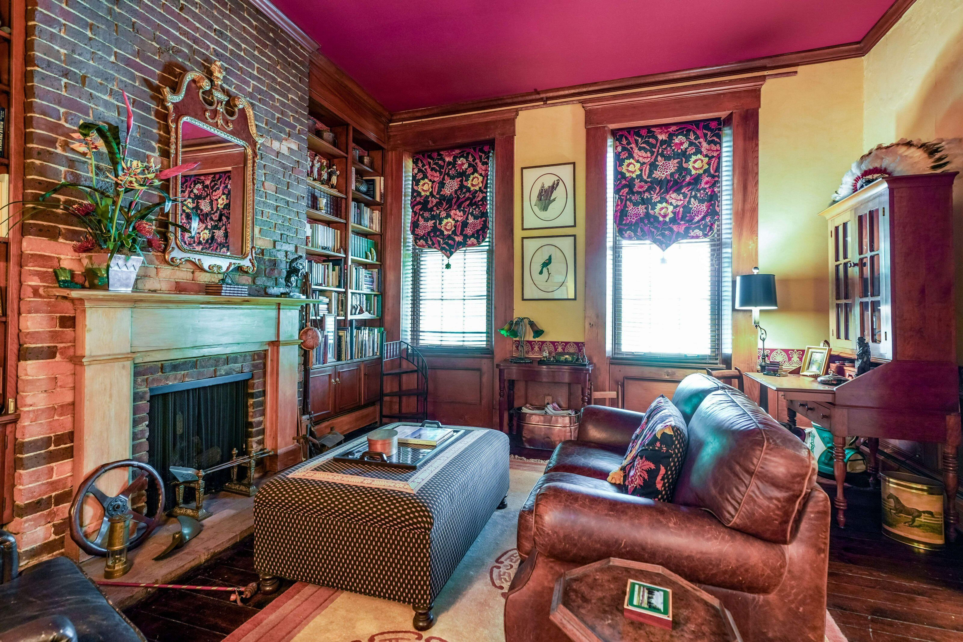 Una sala de estar acogedora con chimenea, sofá de cuero y estantería.