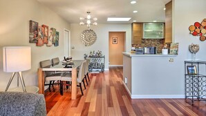 A modern kitchen with a central island, a dining area with a table and chairs, and a hallway with a door leading to another room. - Updated San Diego Home w/ Private Yard & Patio! (San Diego)
