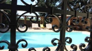 Une piscine entourée d’une clôture en métal décorative.