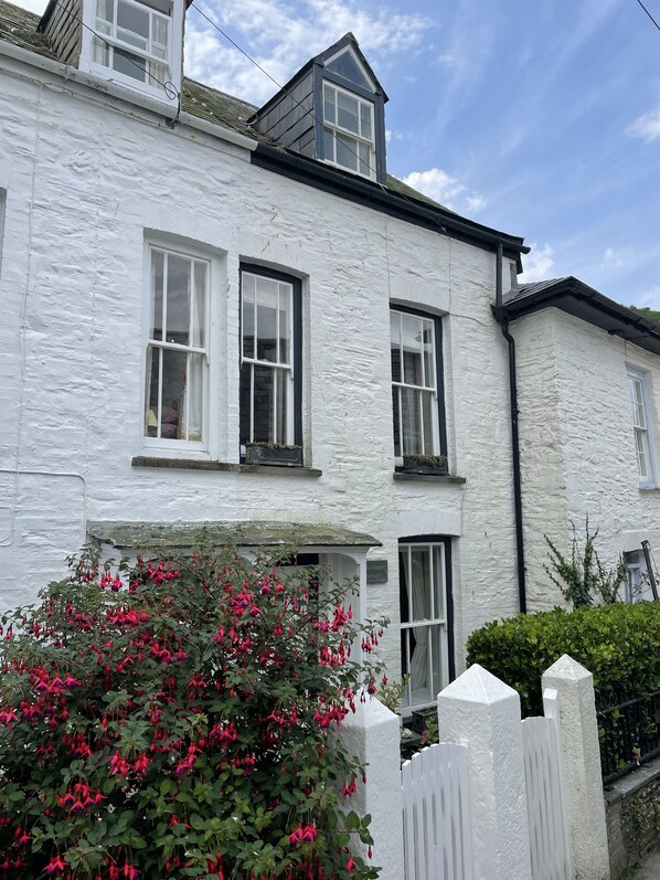 A white two-story building with multiple windows and a small porch. - Brakestone Cottage in the heart of Port Isaac (Port Isaac)