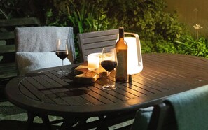 A table with a bottle, two glasses of wine, and a candle. - Brakestone Cottage in the heart of Port Isaac (Port Isaac)