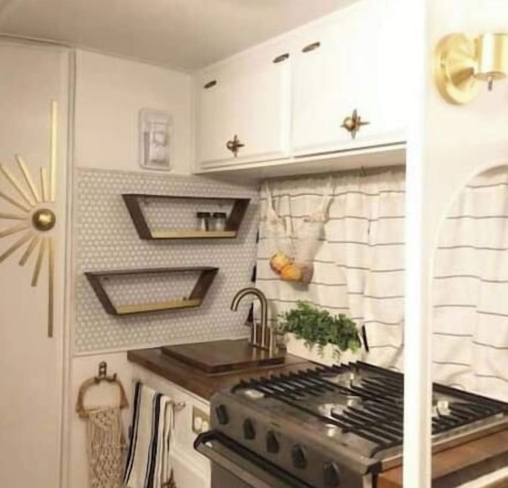 A kitchen with a stove, shelves, and a decorative wall piece.