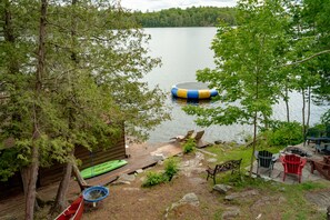 A lakeside deck with outdoor seating and a floating dock.