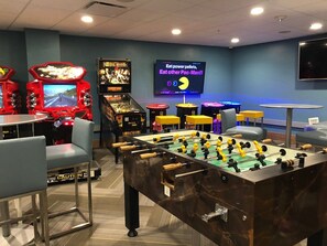 Relax and have fun in our recreational area, featuring a foosball table, arcade games, and a TV for entertainment.