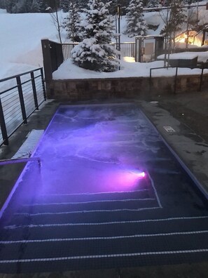 Enjoy a refreshing swim in the heated pool, surrounded by a low wall and metal fence.