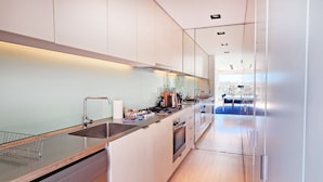 A modern kitchen with a stainless steel sink, a stove, and a refrigerator. - Beachside living at its best! Bondi Beach Apartment. (Bondi Beach)
