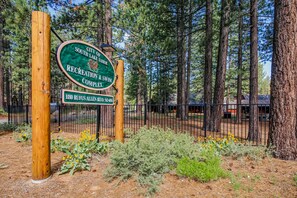 Located near the City of South Lake Tahoe Recreation & Swim Complex, this property is situated in a wooded area with pine trees.