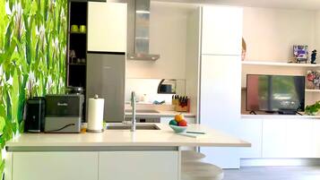 Una cocina moderna con una isla integrada, refrigerador, estufa y pileta.
