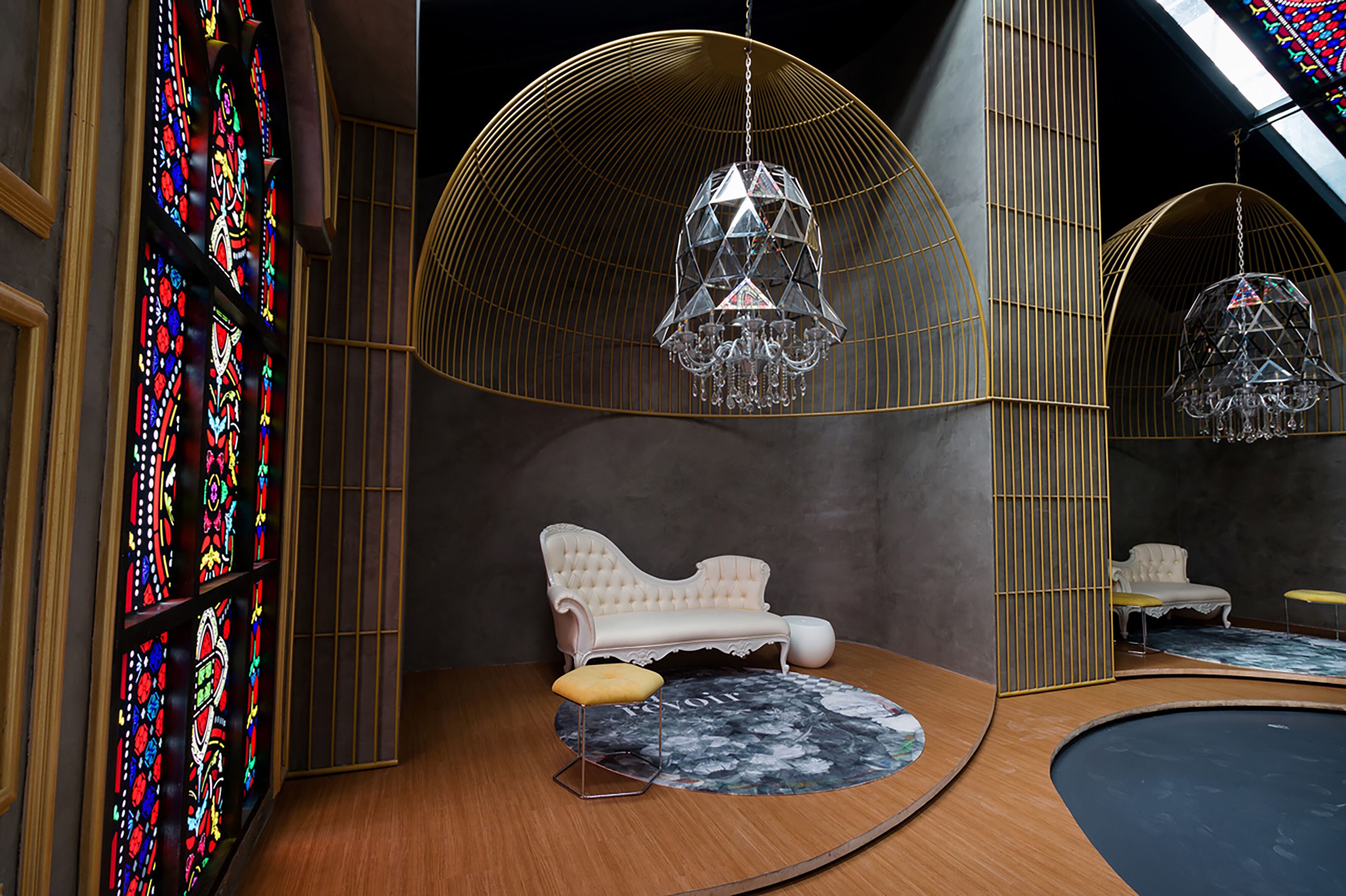Ein Zimmer mit einem weißen Sofa, einem runden Tisch und einer Kristallleuchtre.