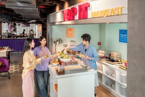 A breakfast buffet area with a sign reading 'TOP IT BREAKFAST' and a variety of food options. - Tru by Hilton Hanoi Station (Hanoi)