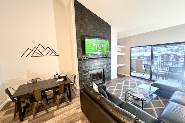 Living Room with new floors, queen sleeper sofa, gas fireplace & 65 inch TV