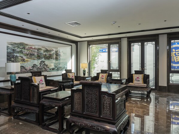 A traditional-style room with wooden furniture, a large painting, and a view through the windows. - San Po Hotel (Fuzhou)