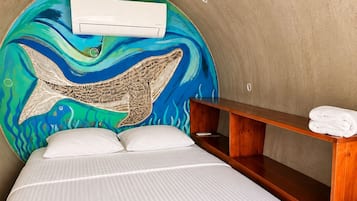 A room with a bed, a wooden bench, and a wall mural.