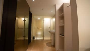 A modern bathroom with a glass shower, a sink, and a storage cabinet.