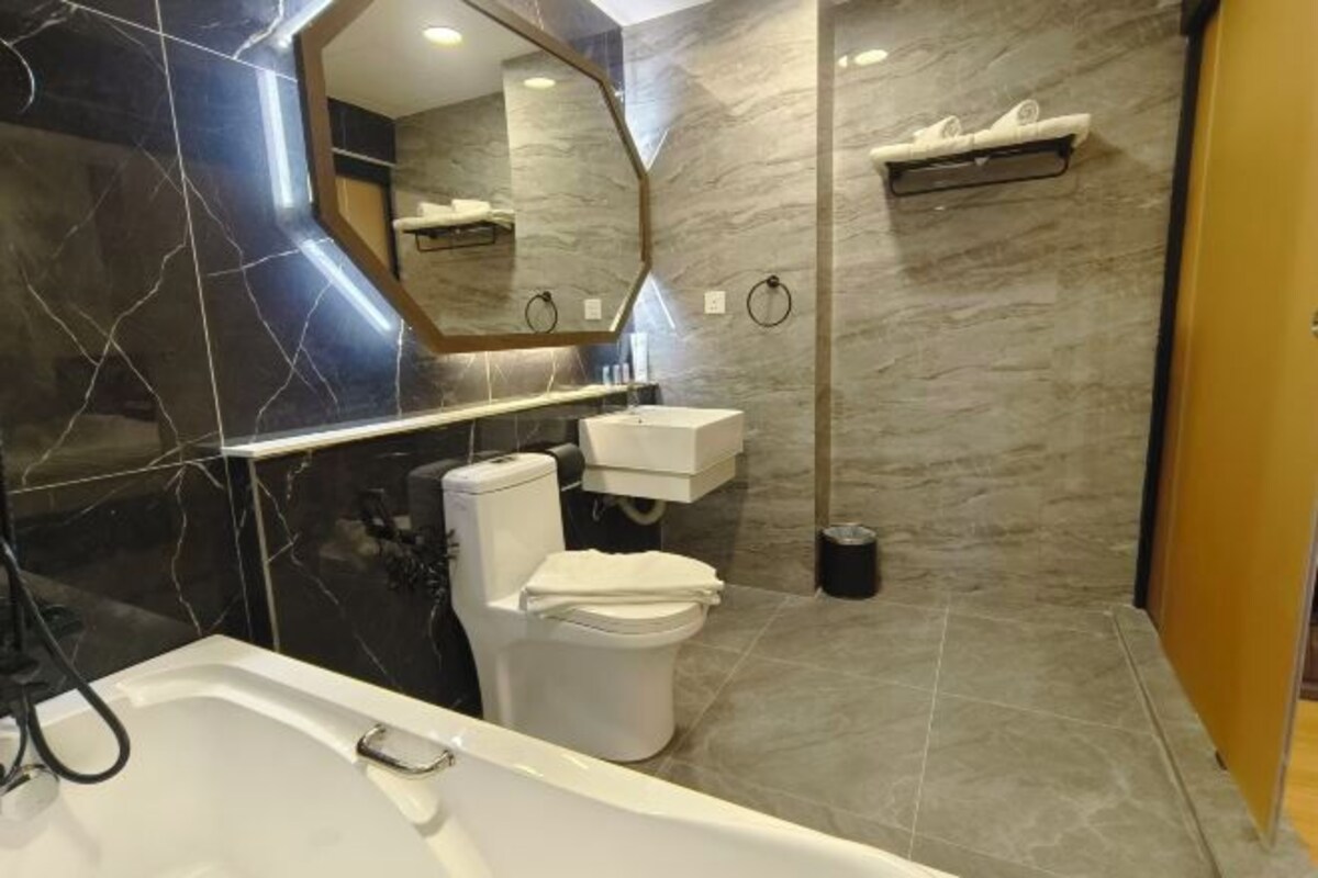 A modern bathroom with a bathtub, toilet, and sink.