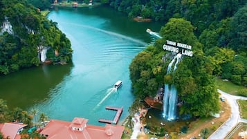 An aerial view of a lake surrounded by lush greenery and a waterfall.