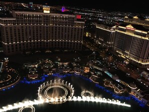 Een groot hotel met meerdere verdiepingen, een opvallend casino en een fontein.