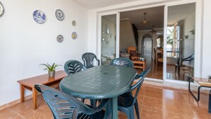 Un comedor con una mesa y sillas, una planta en maceta y platos decorativos en la pared.