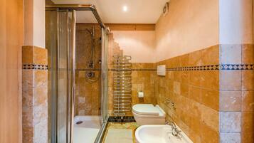 A bathroom with a shower, toilet, and sink.