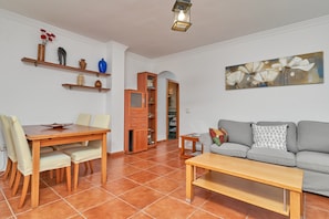 A living room with a dining table, sofa, and artwork.