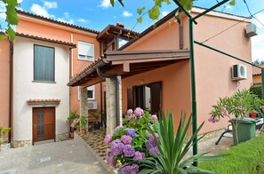 A two-story house with a tiled roof, a stone staircase, and a garden with purple flowers. - Apartment 295/45496 (Istria - Stinjan), 1000m from the beach (Stinjan)