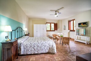 A bedroom with a bed, a desk, a chair, a television, and a ceiling fan. - Torrenova di Assisi Country House (Assisi)