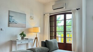 Une chambre à coucher avec un lit, un bureau, une lampe et une fenêtre avec des rideaux.