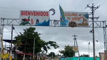 Un ingresso con un cartello 'BIENVENIDOS' e un banner 'CALIMA Magic Y Ancestoral'.