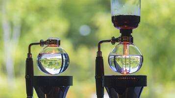 Two laboratory glassware setups with transparent spheres and black stands, placed against a blurred green background.