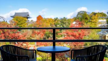 Un balcon avec deux fauteuils en osier noir et une petite table ronde.