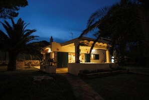 Enjoy a peaceful evening on the central patio surrounded by lush greenery and palm trees.