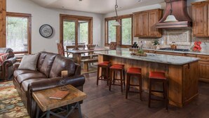 Una cocina amplia con una isla grande, armarios de madera y una lámpara colgante.